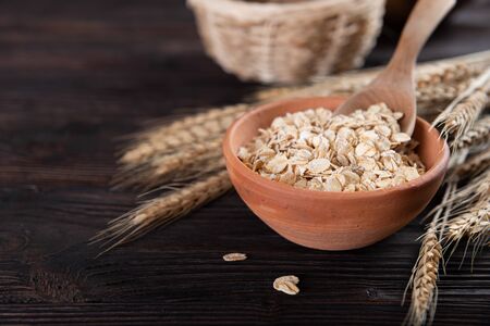 Dry rolled oat flakes oatmeal on old wooden table
