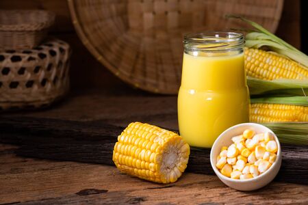 Fresh sweet corn juice (corn milk) and corn on wooden backgroundの写真素材
