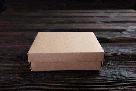 Cardboard box on a dark rustic wooden background