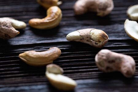 Roasted shelled cashews on natural wooden table background