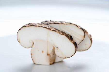 Shiitake mushrooms (Lentinus edodes) in white plate on the wooden background.の写真素材