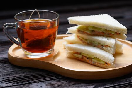 Hot Tea with Tuna Sandwich on wooden plate wood backgroundの写真素材