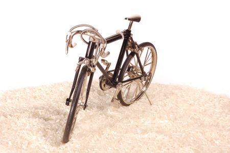 Toy bike standing on white riceの写真素材