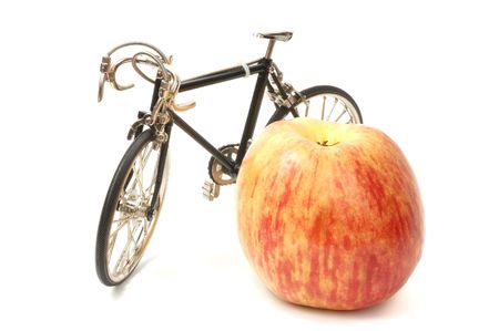 Metal bicycle and red apple, isolated on whiteの写真素材