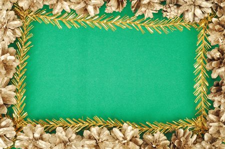 Green christmas background with gold cones frameの写真素材