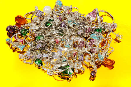 Stack of gold jewelry  on yellow backgroundの写真素材