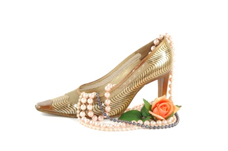 Woman golden shoe with pearl necklace   on a white backgroundの写真素材