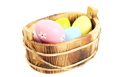 Colorful painted Easter eggs in a wooden plate, white backgroundの写真素材