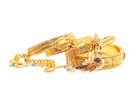 Golden bracelets and necklace with diamonds, over whiteの写真素材