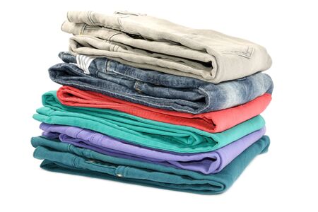 Stok of colorful folded jeans, closeup, on white background