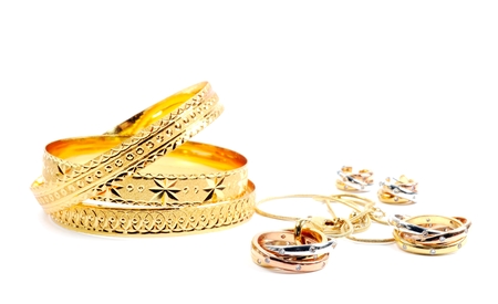 Golden bracelets and jewelry sets, over whiteの写真素材