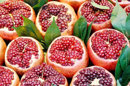 Opened fresh pomegranates with leafes, closeup shot
