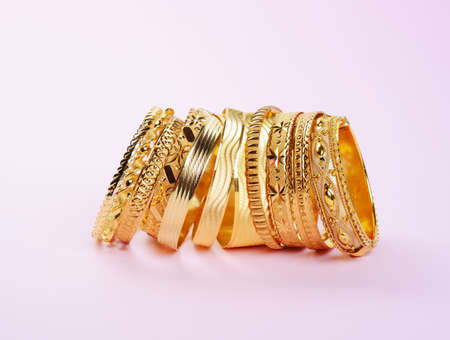 Womans precious golden bracelets, on a pinkの写真素材