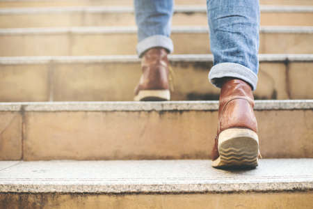 Close up image of young hipster wearing blue jeans and shoes leather walking at city stairs during travel destination to grow and learn experience.の写真素材
