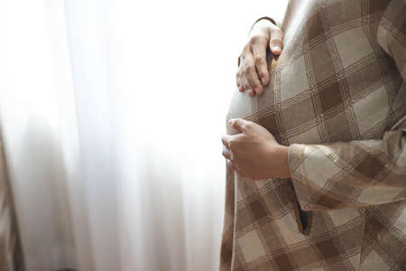 Close up of a pregnant belly., motherhood Concern for the unborn child.の写真素材