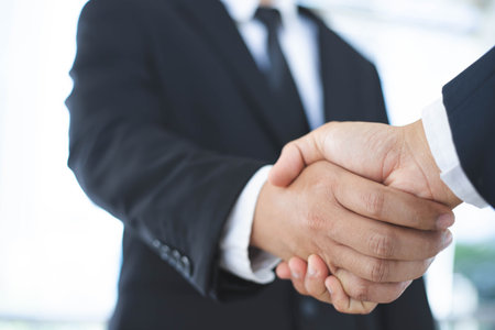 A close-up picture of a businessman shaking hands on a business cooperation agreement in the heart of the city. Concept of Cooperation business and successの写真素材
