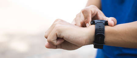 Close-up sporty man hand with watch for check statistic or heart rate.After finishing exercise.Fitness and healthy lifestyle concept.の写真素材