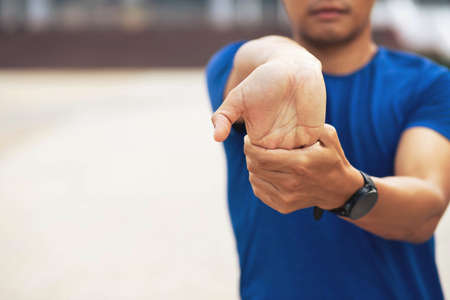 Sporty man stretching exercise for warming up before running in the park or gym workout. Fitness and healthy lifestyle concept.の写真素材