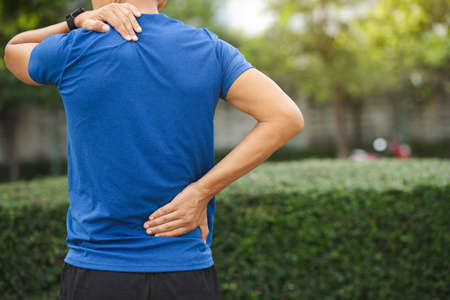A man back pain after exercise concept.It happens often in athletes practice overtain,Lifting heavy objects or office syndrome.A Muscle inflammation concept.の写真素材