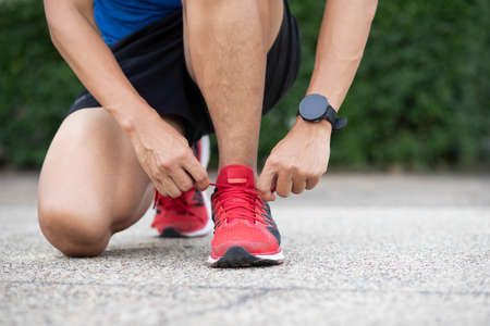 Close up of sportsman tying shoelace.Get ready to start exercising.healthy lifestyle concept.の写真素材