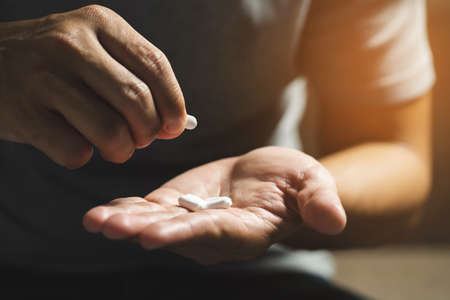 Close up image medicines pill in young man hand. health care concept.の写真素材