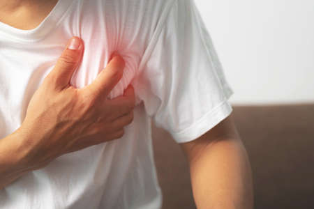 A man white shirt clutching his chest caused by a sudden heart attack.healthcare concept.の写真素材