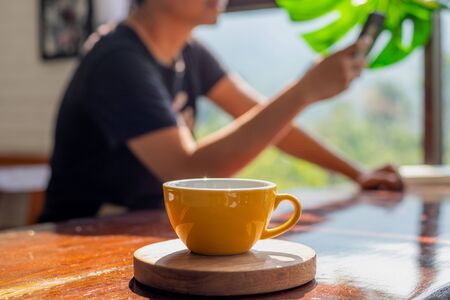 Yellow cup on wooden coasterの写真素材
