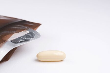 A capsule of medication peeled off the package on the white backgroundの写真素材
