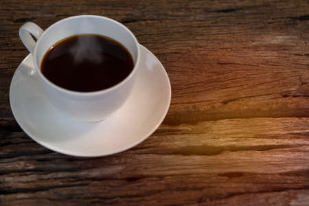 A hot coffee in the white cup on the tableの写真素材