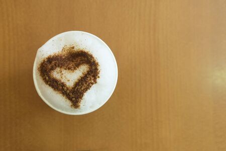 A tasty cup of cappuccino on the wooden tableの写真素材