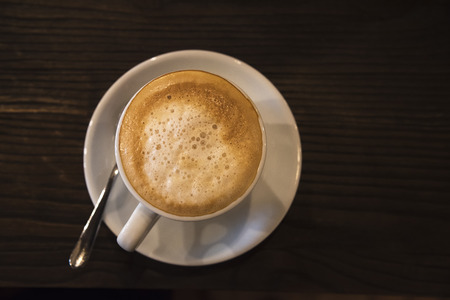 Top view of a tasty cup of cappuccino on the wooden tableの写真素材