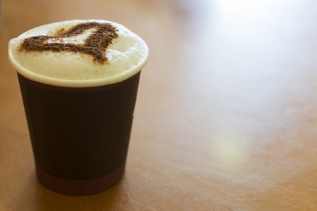 A tasty cup of cappuccino on the wooden tableの写真素材