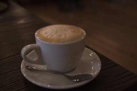 A tasty cup of cappuccino on the wooden table