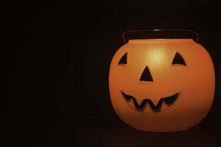 Halloween pumpkin basket on the black background with candle light insideの写真素材