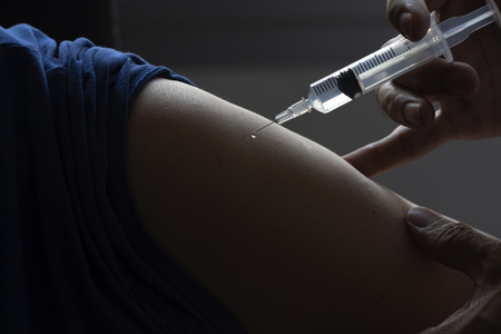 Doctor holding a syringe and needle for vaccine injectionの写真素材