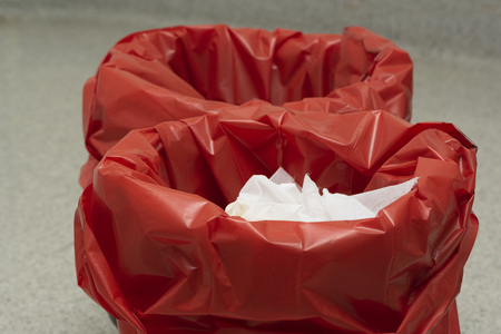 Used surgical gloves in Two red garbage bins in operating roomの写真素材