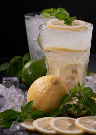 Two glass of tasty ice lemon juice on the table and black backgroundの写真素材