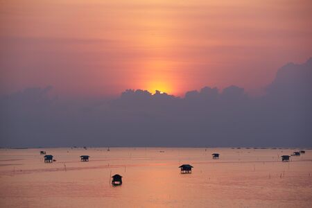 Beautiful sunrise behind the clouds over the gulf of Thailand, Bangtaboon, Petchaburi,Thailandの写真素材