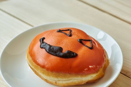 A plate of tasty halloween doughnut on wooden backgroundの写真素材