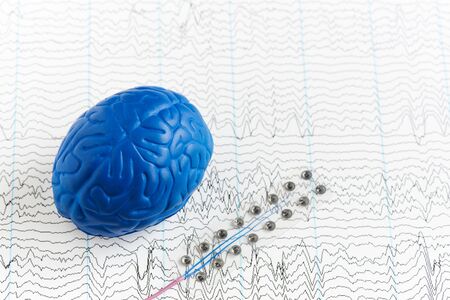 Subdural grid electrode for brain waves recording or electroencephalography and artificial brain model on EEG backgroundの写真素材