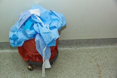 Blue surgical gowns in the garbage after finishing surgery in operating roomの写真素材