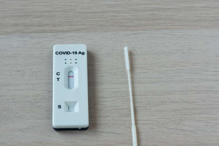 Rapid antigen test kit and negative result of covid-19 infection, nasal swab on the table.