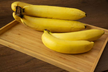 Two bunches of delicious banana on wooden background.の写真素材
