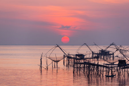 Sunrise and silhouette image of giant fishing net in the morning at Pakpra, Phatthalung, Thailand.の写真素材