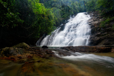 A captivating scene of the Ton Prai Waterfall cascading through a verdant forest in Phang Nga, Thailand.の写真素材