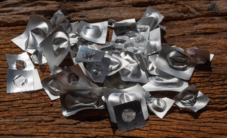 Empty blister packs scattered on wooden surface, highlighting waste.