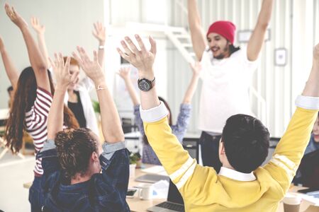 Young multiethnic diverse creative asian group huddle and high five hands together in office...