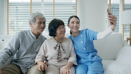 Young senior asia citizen couple and assisted home living nurse care hold mobile phone selfie...