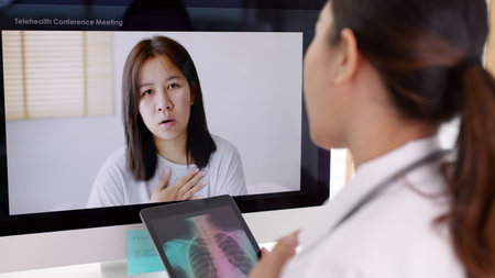 Attractive beautiful asia   female doctor video conference call online live talk follow up remotely in medical coronavirus result with patient at office. Online telehealth telemedicine service.の写真素材