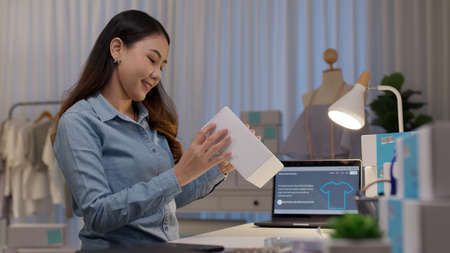 Young attractive beautiful hipster asia female packing product small business parcel order online retail store for delivery to customer. SME owner work preparing dropshipping box at home office.の写真素材